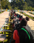 Workers turning coffee beans on drying beds at Rumudamo Station.